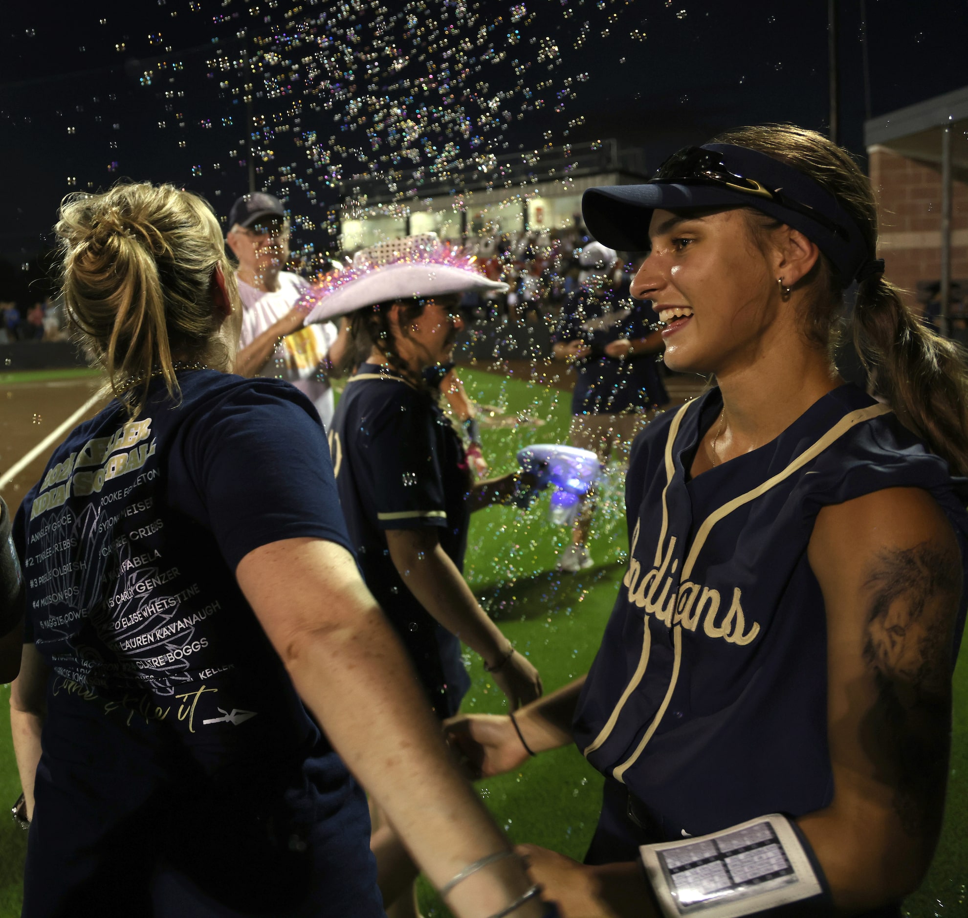 Keller catcher Kaiya Febela (14), right, celebrates with teammates following their 10-0...