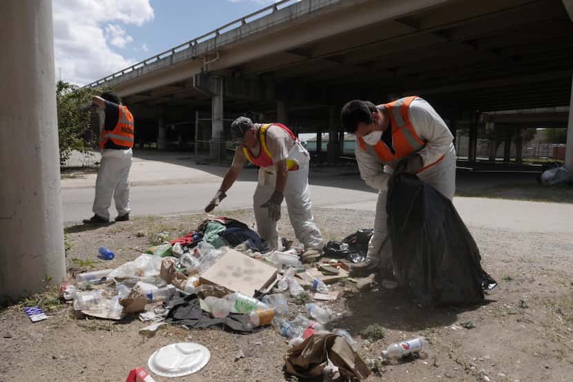 A work crew from Green Planet Inc. Environmental Services cleans up trash helps the City of...