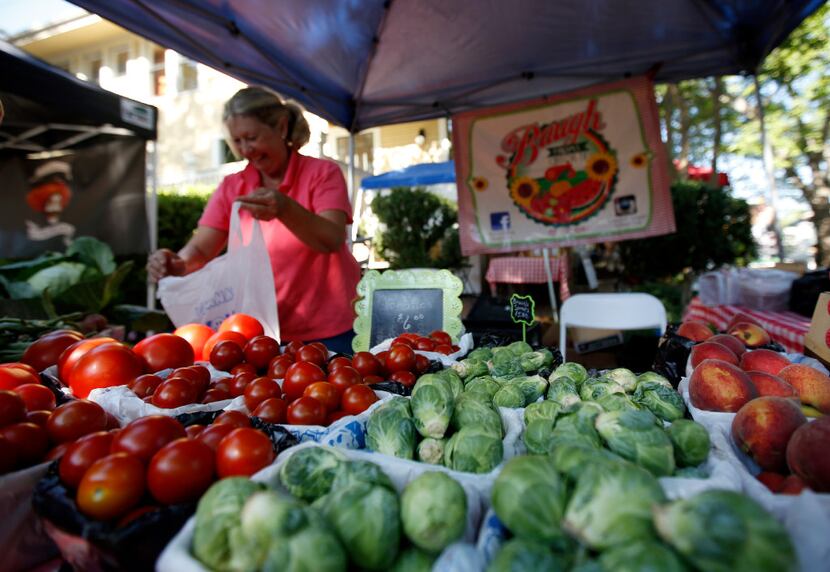 Marla Baugh of Baugh Farms bags tomatoes at the McKinney Farmers Market