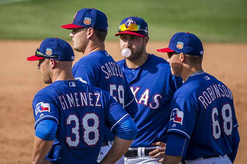 Texas Rangers third baseman Joey Gallo blows a bubble as he waits with Chris Gimenez (38)...