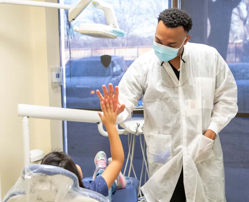 Dr. Dan Burch, 38, high fives a patient at HHM Health. Burch started a fellowship at the...