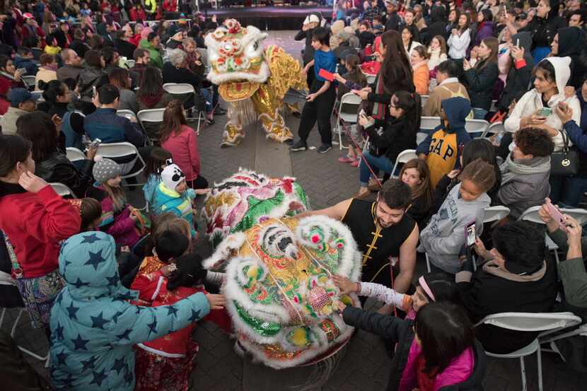 After the lion dance performers mingle with the audience during the Chinese New Year...