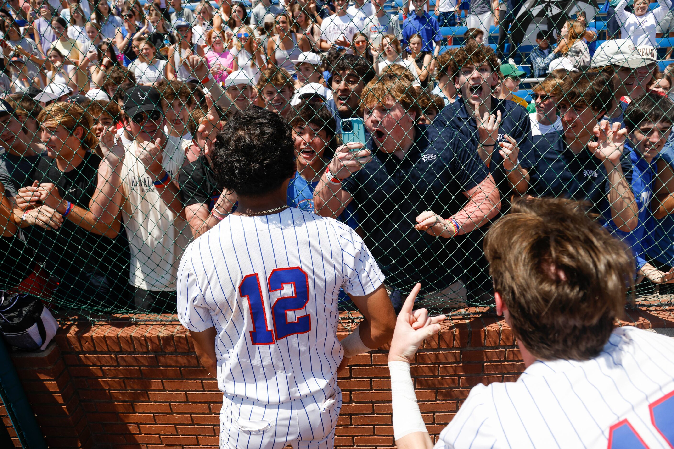 Trinity Christian’s Steven Ramos (12) runs to greet fans after defeating Houston St. Thomas,...