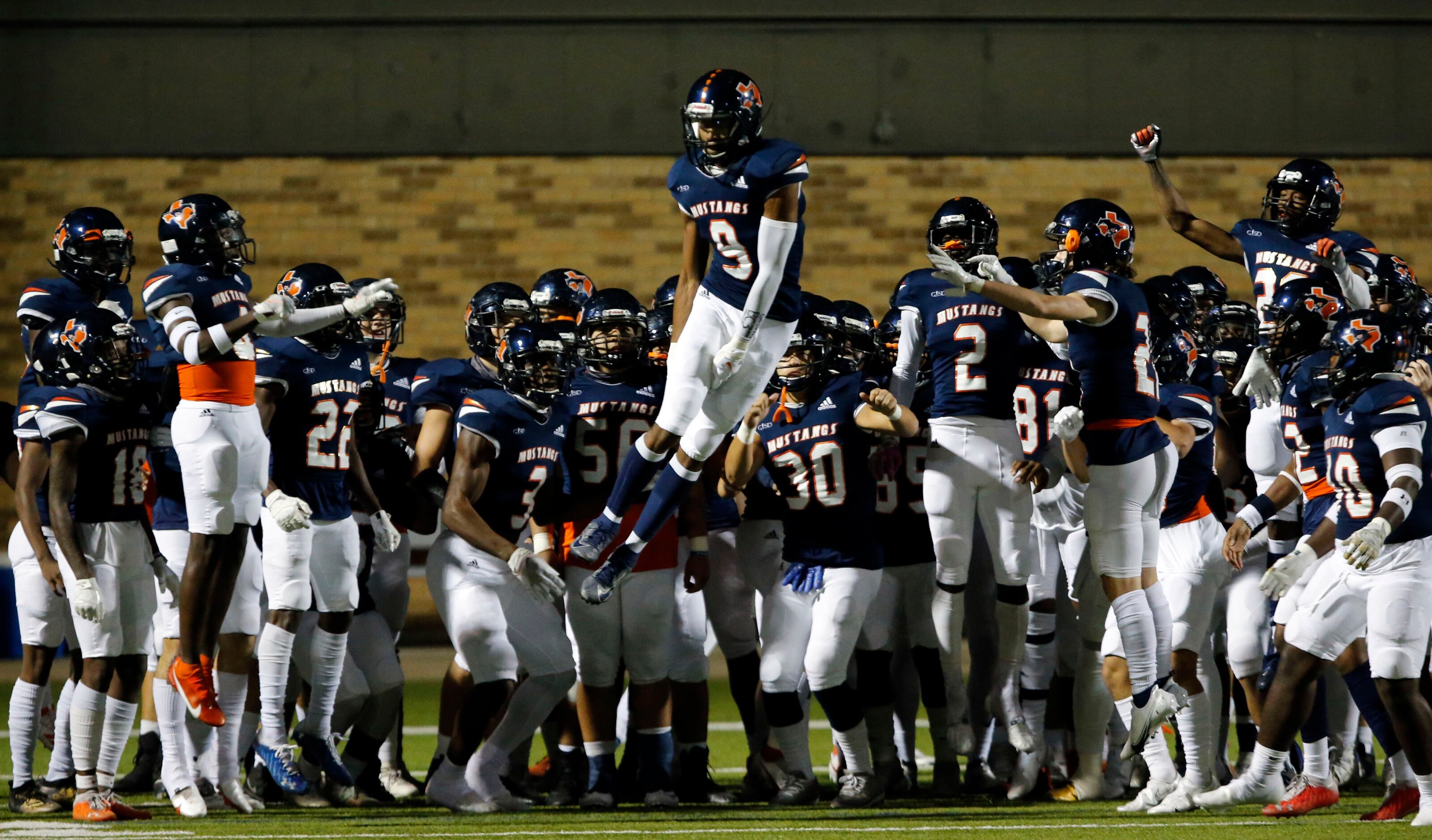 Sachse’s DeAndre Robb (9) spins in the air to the delight of  teammates, as they enter the...