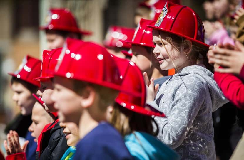 
Members of the North Lamar Second Grade Choir, wearing firefighter hats, lent their voices...