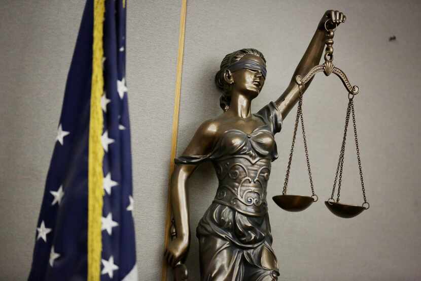 A statue of Lady Justice in a courtroom in the Frank Crowley Courts Building in Dallas 