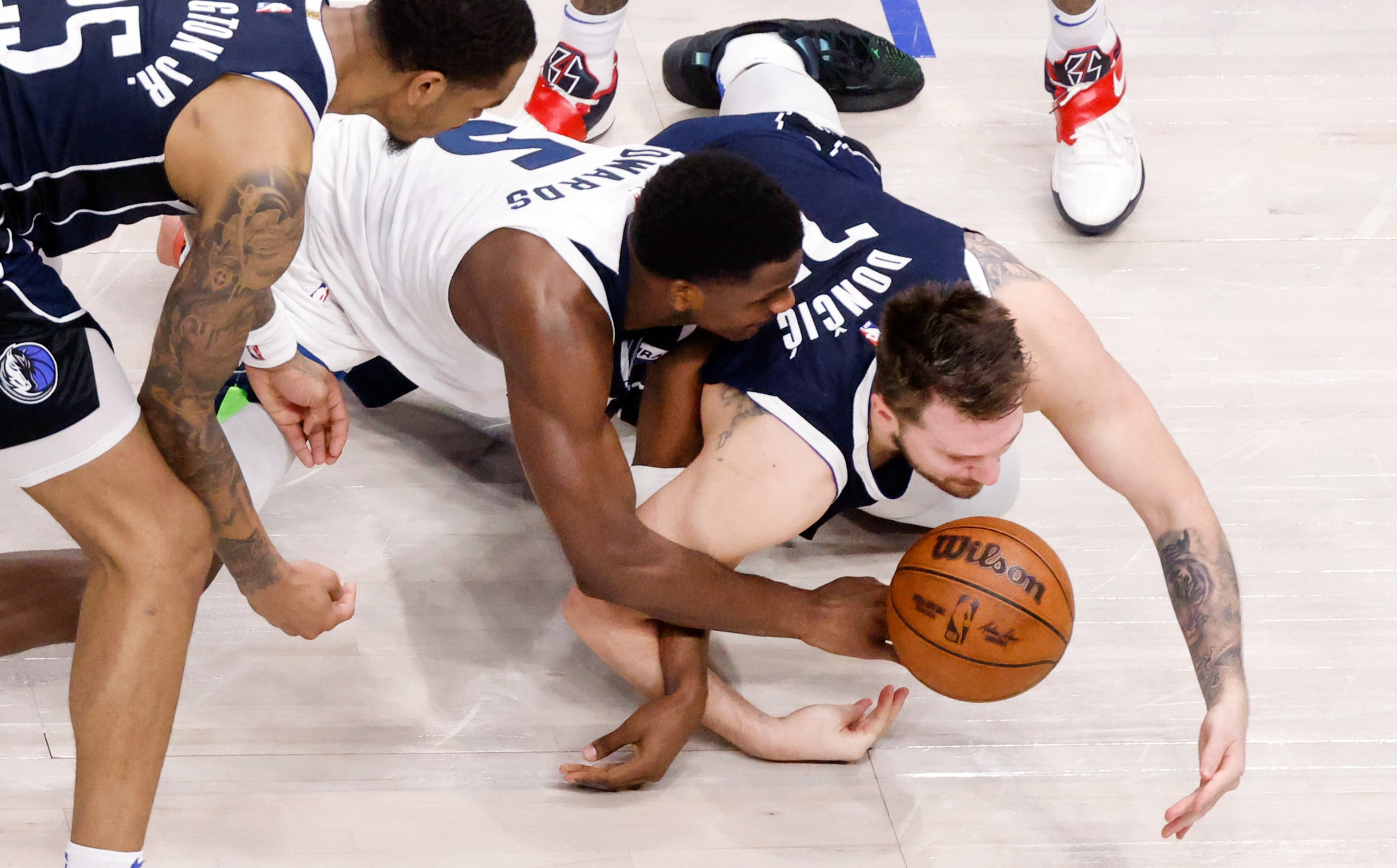 Dallas Mavericks guard Luka Doncic (77) attempts to steal the ball from Minnesota...