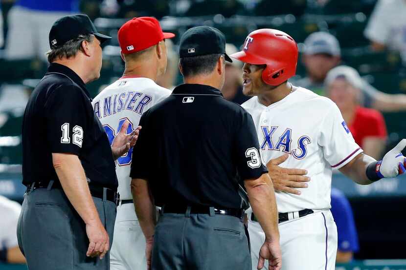 Texas Rangers third baseman Adrian Beltre (29) and manager Jeff Banister argue with umpires...