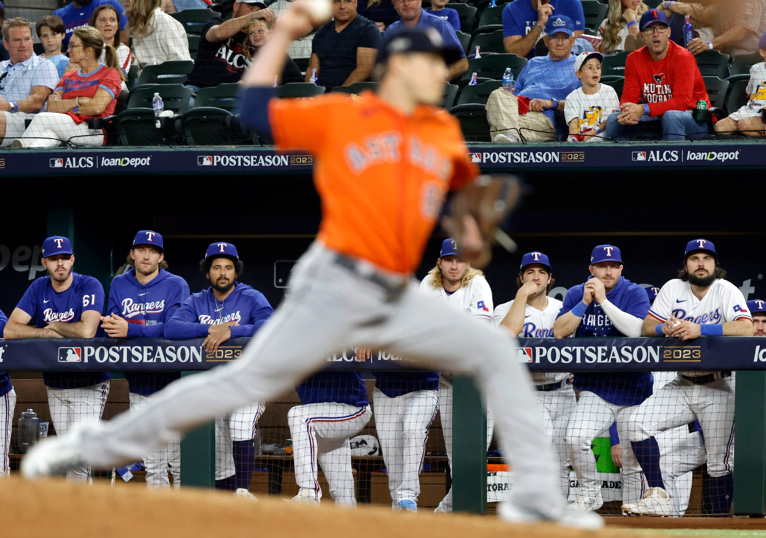 Texas Rangers players hang on the dugout watching Houston Astros relief pitcher Phil Maton...