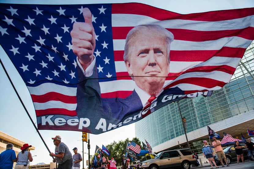 Randal Thom, 60, of Minnesota, waves an oversized flag of President Donald Trump outside the...