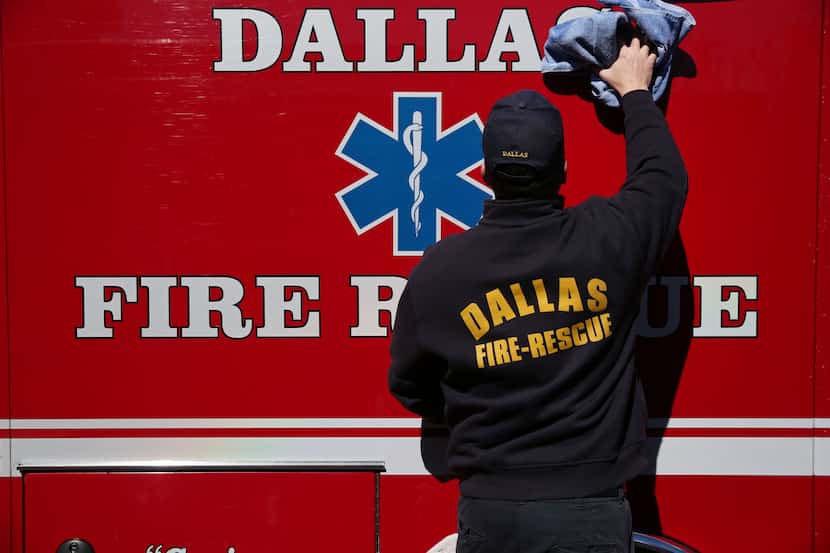 Firefighter John Smith cleans a vehicle outside Dallas Fire-Rescue Department fire station...