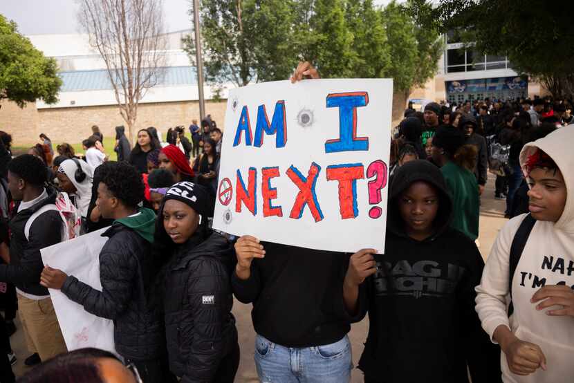 Students hold up a sign that says “Am I next?” as they stage a “walkout” following a...