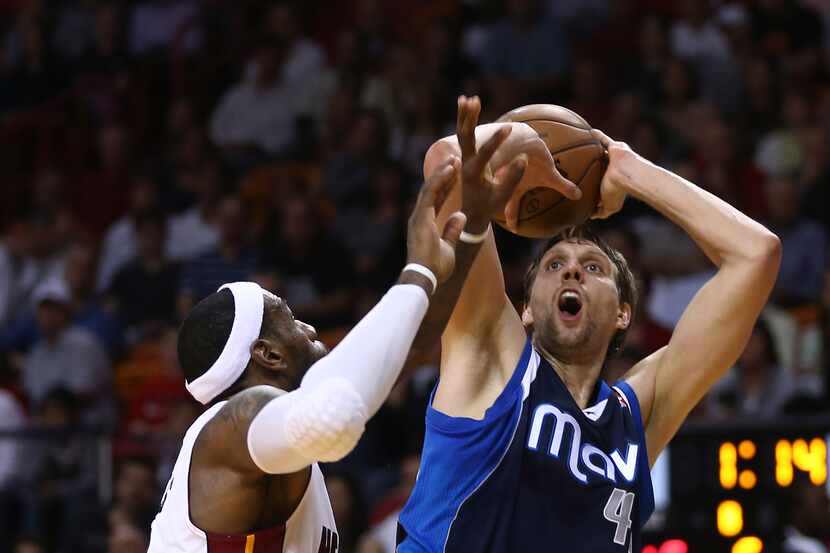 Miami Heat's LeBron James, left, is unable to block Dallas Mavericks' Dirk Nowitzki (41)...