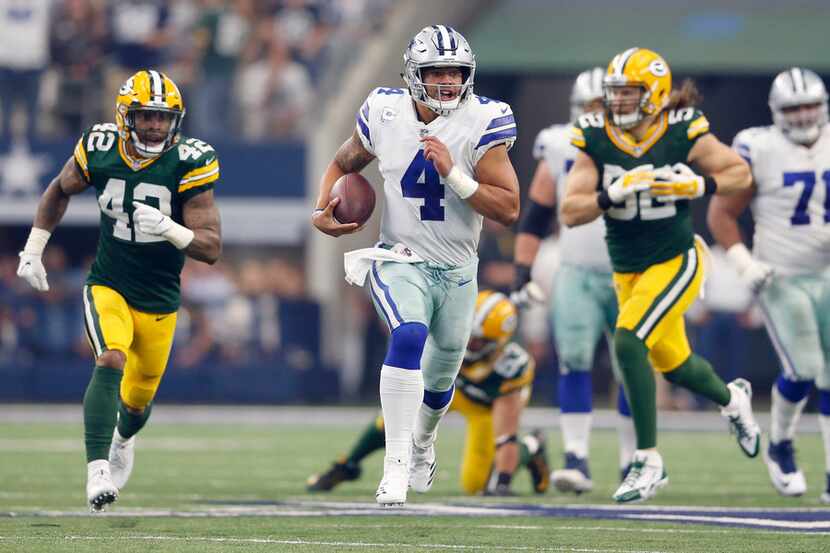 Dallas Cowboys quarterback Dak Prescott (4) runs up the field in a game against the Green...