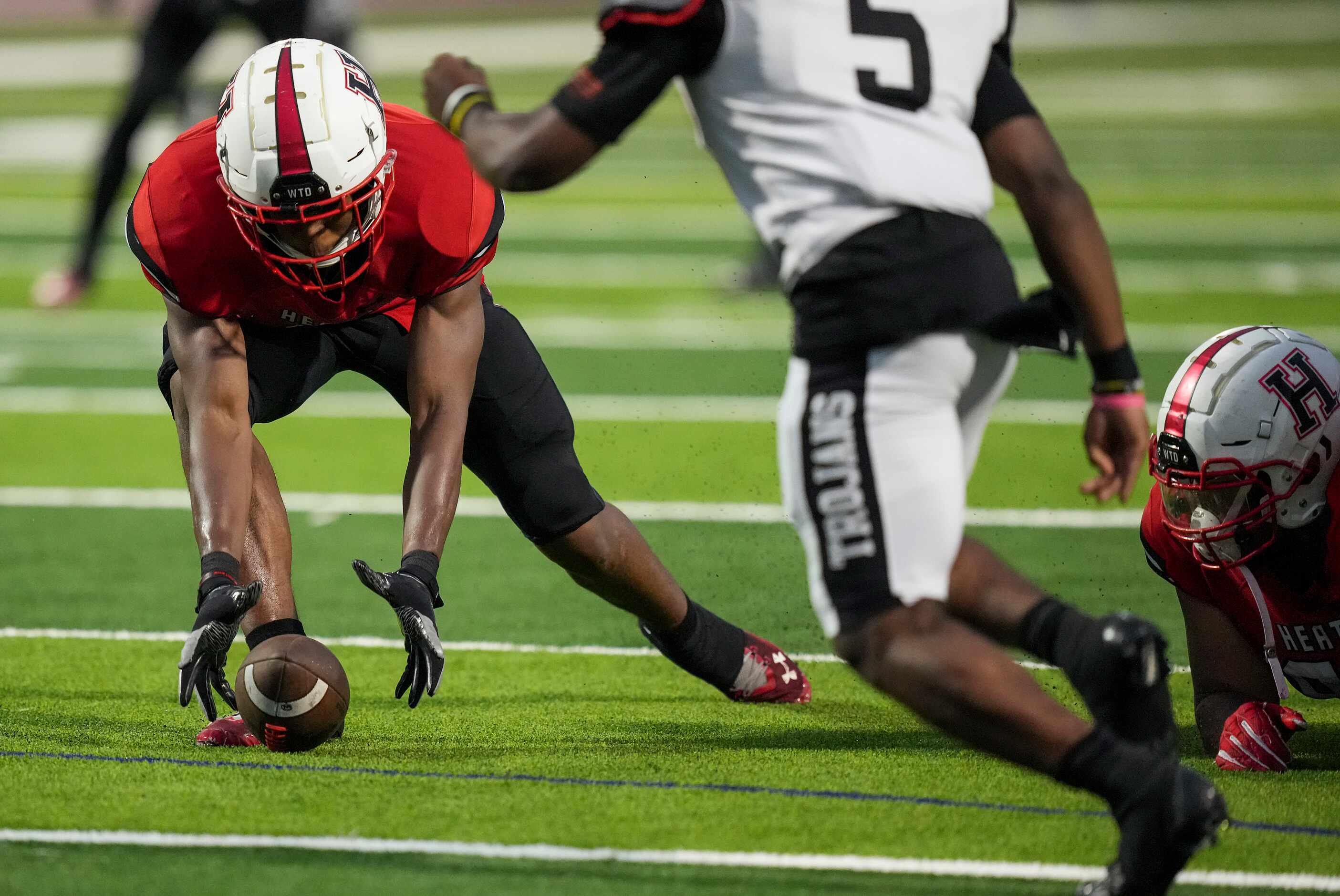 Rockwall-Heath linebacker Jayden Lexion (41) scoops up a Euless Trinity fumble and returns...
