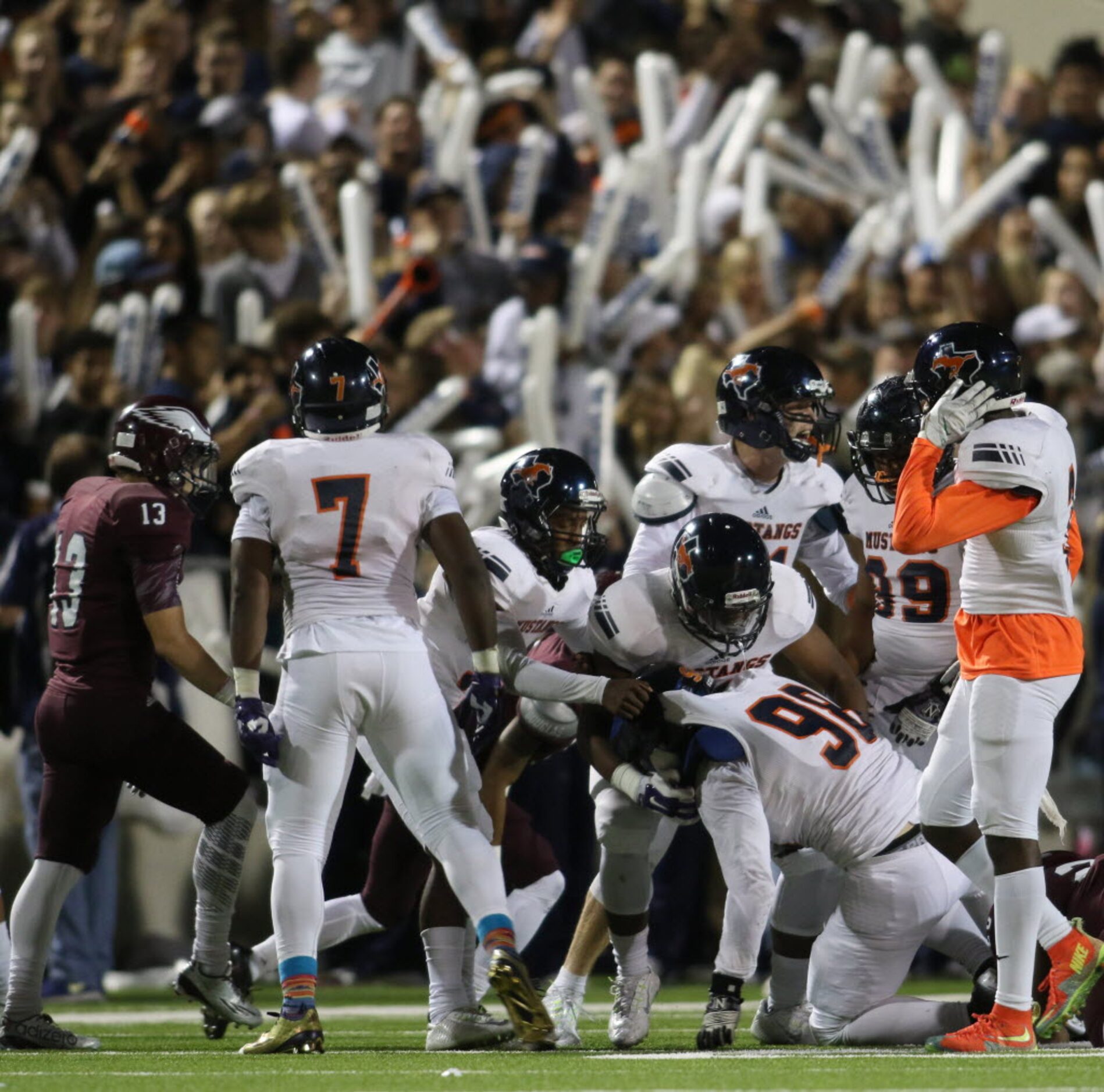 Members of the Sachse defensive squad help defensive lineman Tony Krasniqi (98) to his feet...