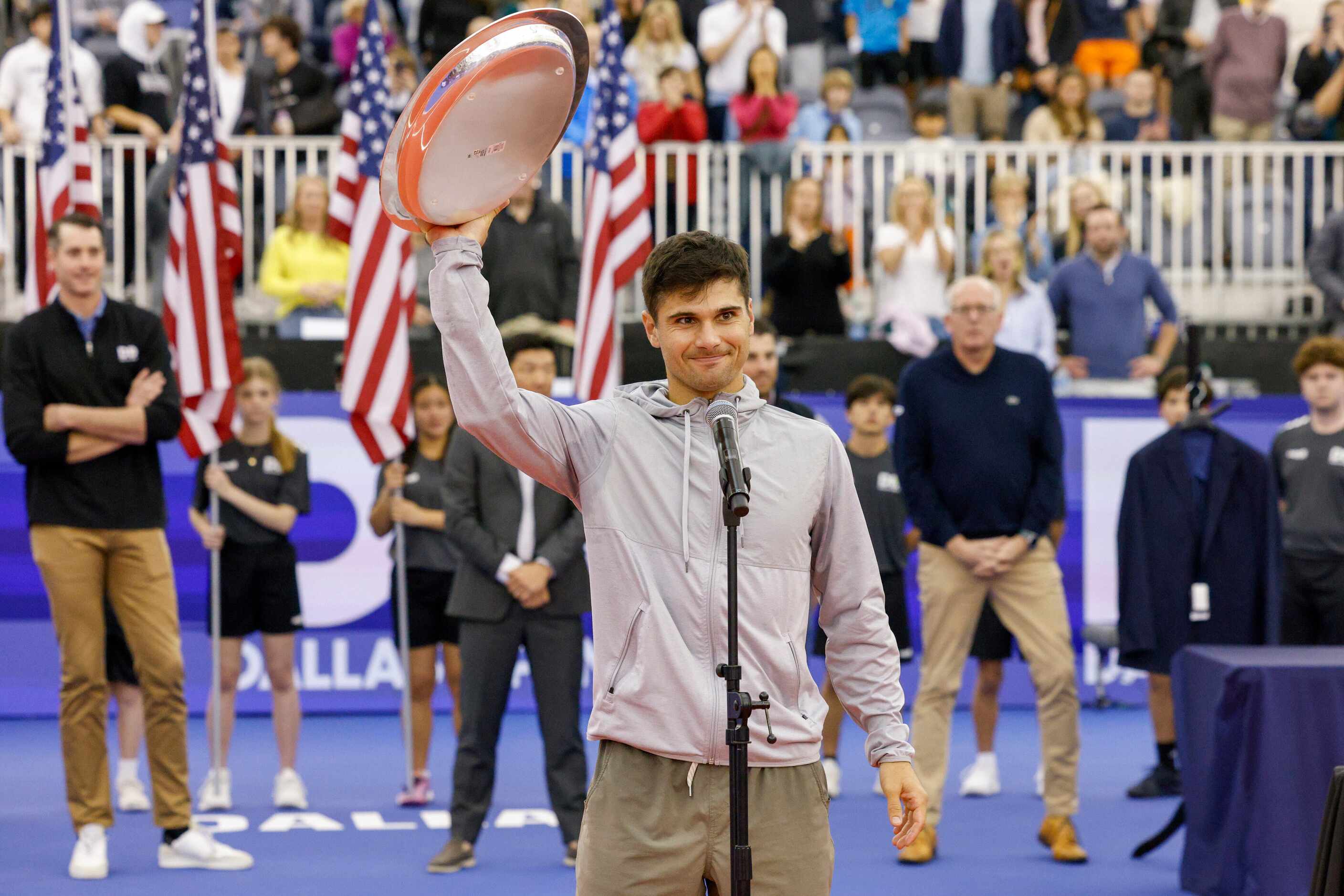 Marcos Giron of the U.S. raises the runner-up trophy after the ATP Dallas Open men's singles...