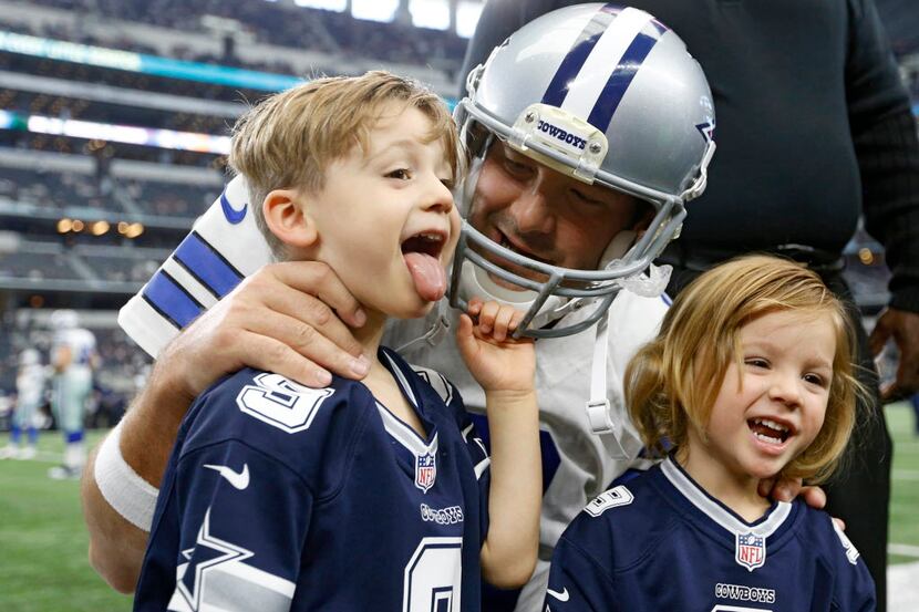 Hawkins Romo makes a face as he takes a photo with Dallas Cowboys quarterback Tony Romo as...