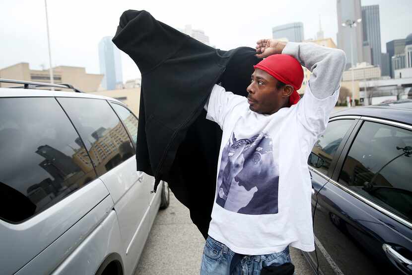 Elton Pearson tries on a donated jacket in a parking lot along Cadiz Street.