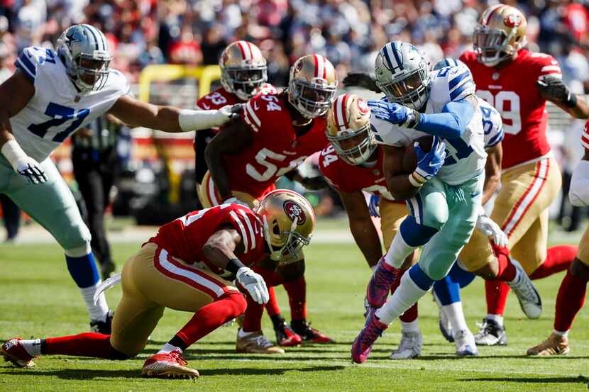 Dallas Cowboys running back Ezekiel Elliott (21) breaks through the San Francisco 49ers...