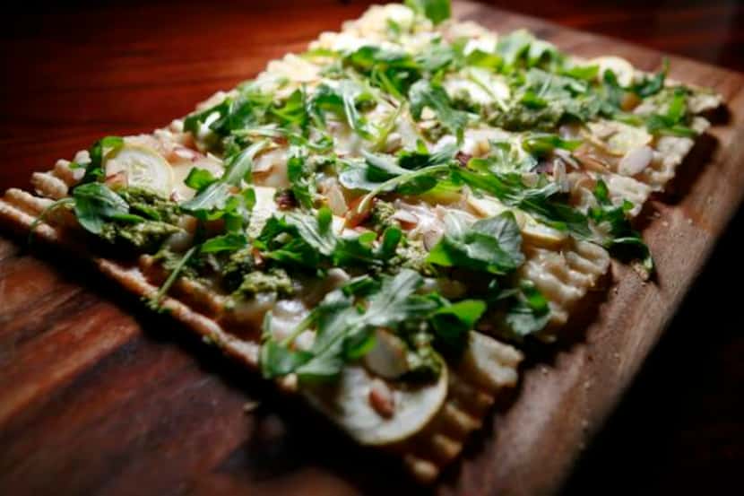 
Flat bread topped with shaved yellow zucchini, caramelized onions, pea pesto and almonds
