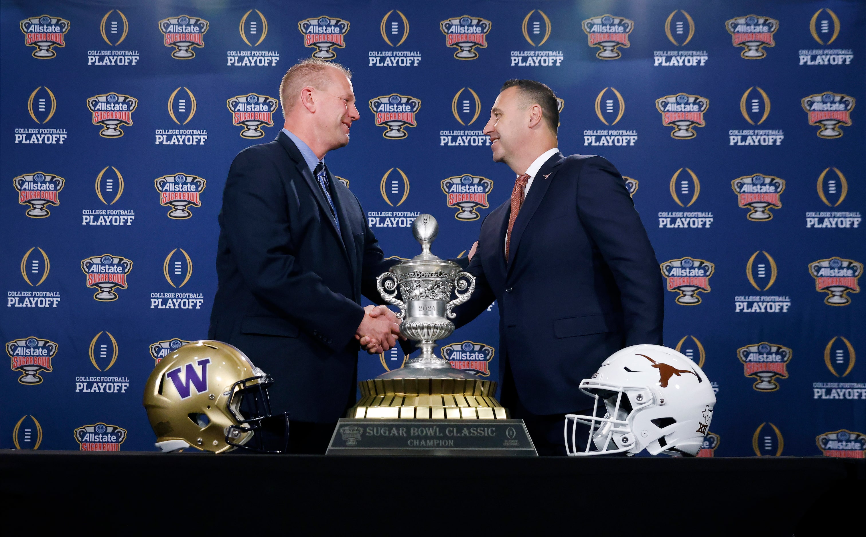 Washington head coach Kalen DeBoer (left) and Texas head coach Steve Sarkisian shake hands...