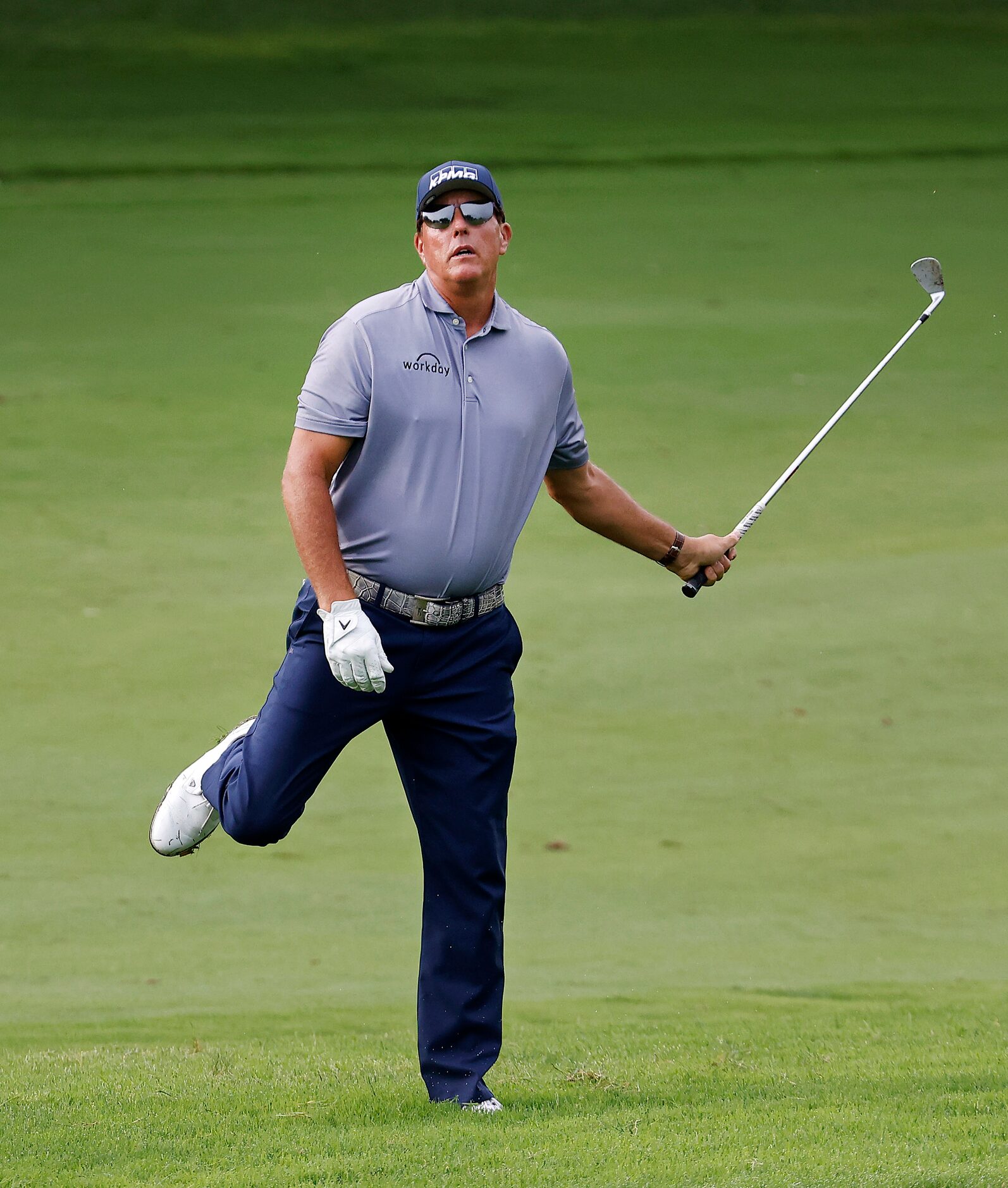 Professional golfer Phil Mickelson reacts to his approach shot from the No. 12 fairway that...