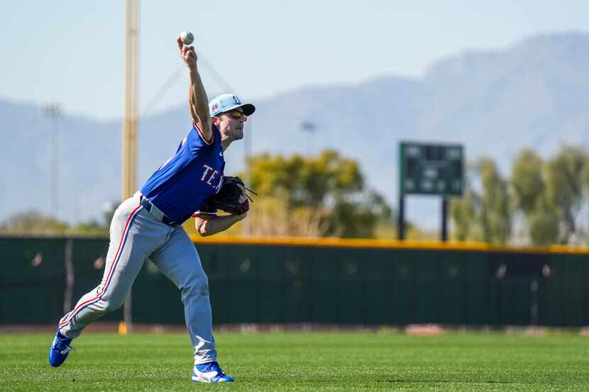 Texas Rangers pitcher David Robertson throws in the outfield during a spring training...