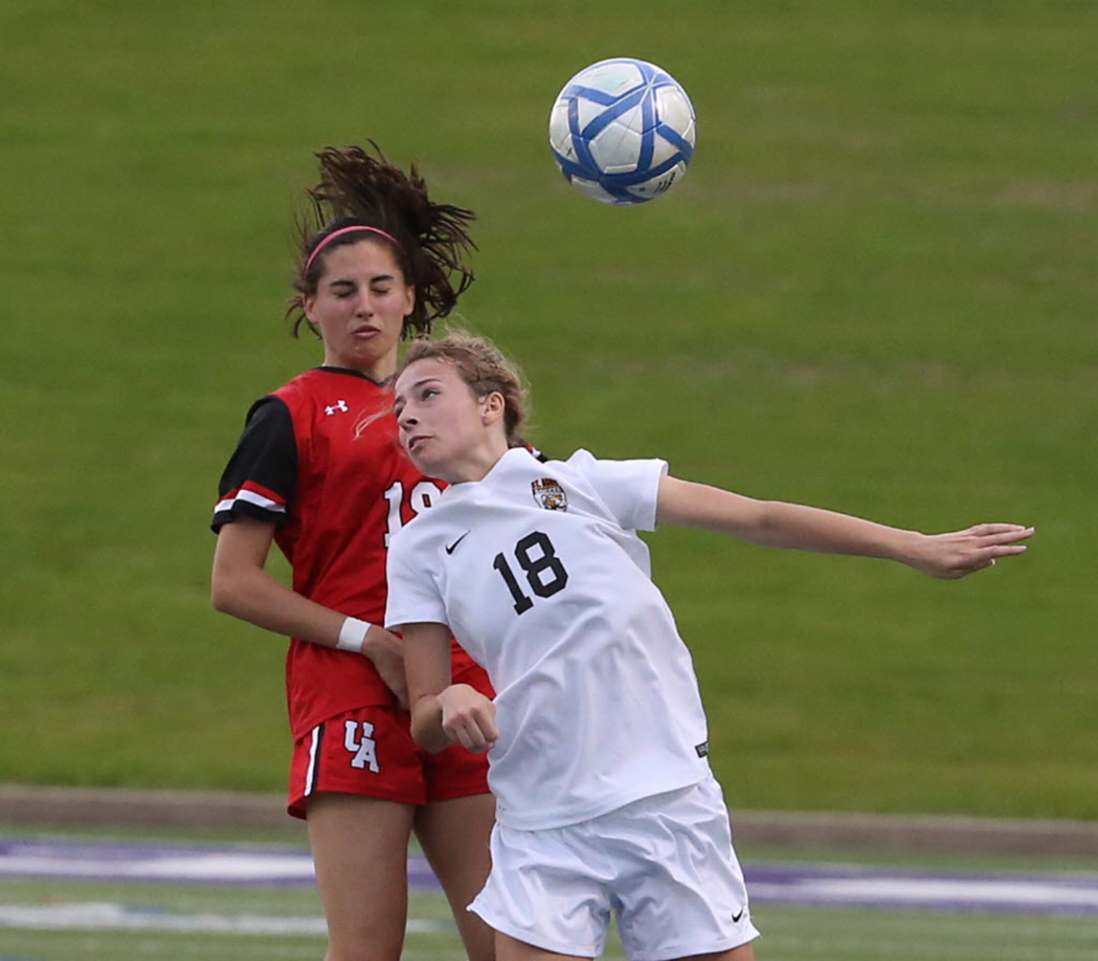 St. Agnes Academys Mary Dade (18) and Ursuline Academys Peyton Robertson (18)  leap for...