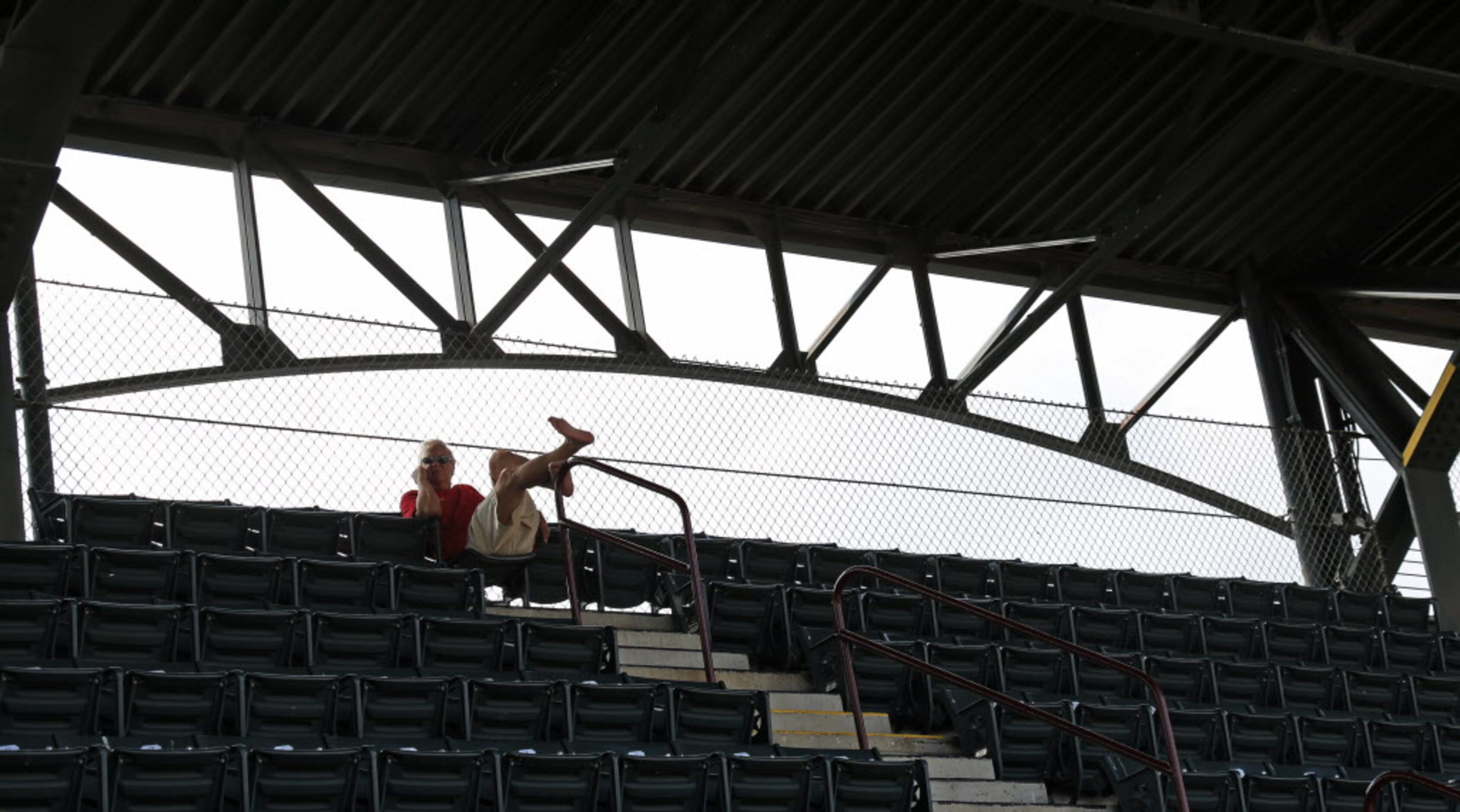 A lone baseball fan watches the action from the last row of the upper deck in right field...