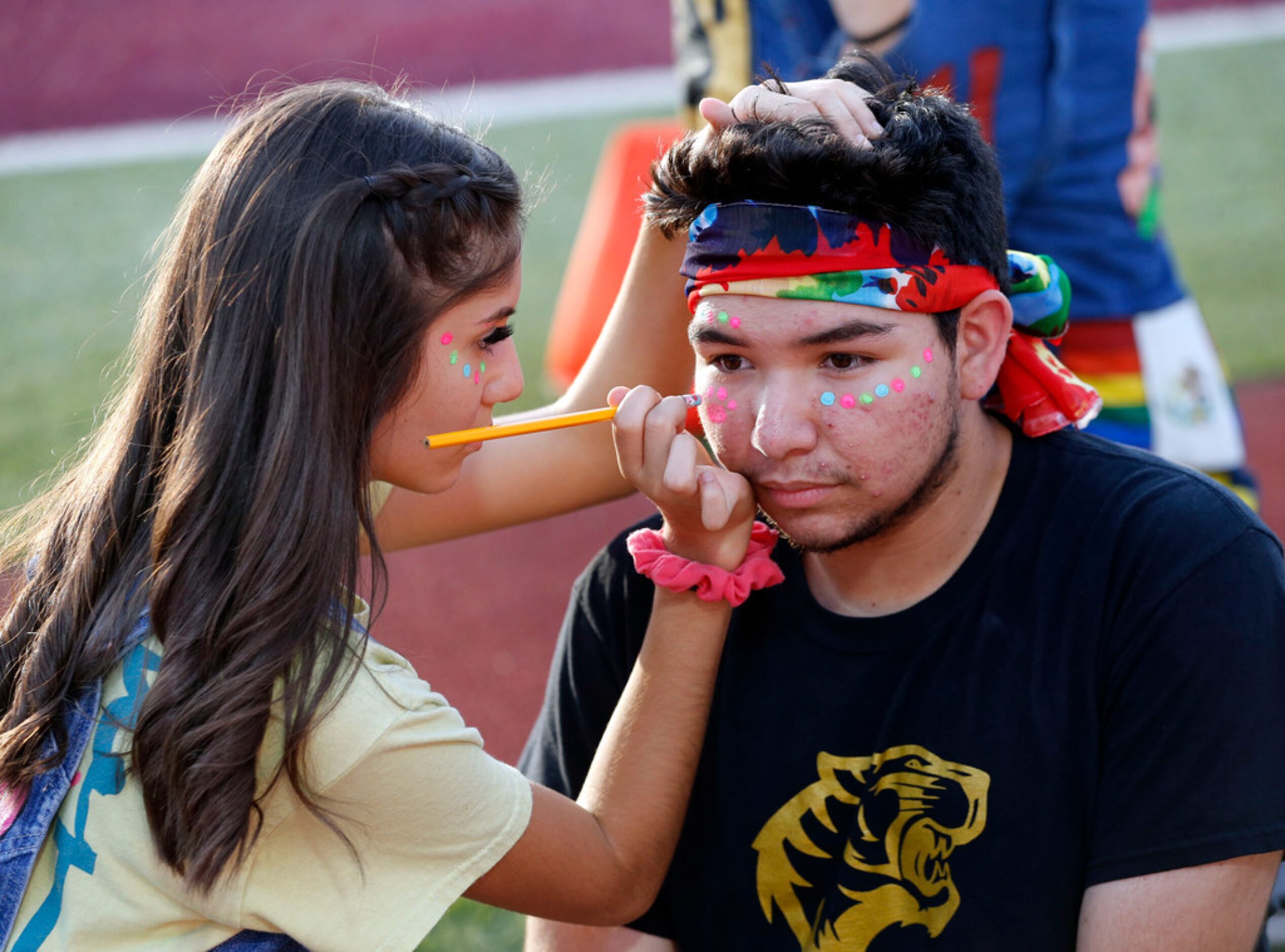 Irving High spirit squad member Jose Santiesteban, a senior, has his face painted by Valeria...