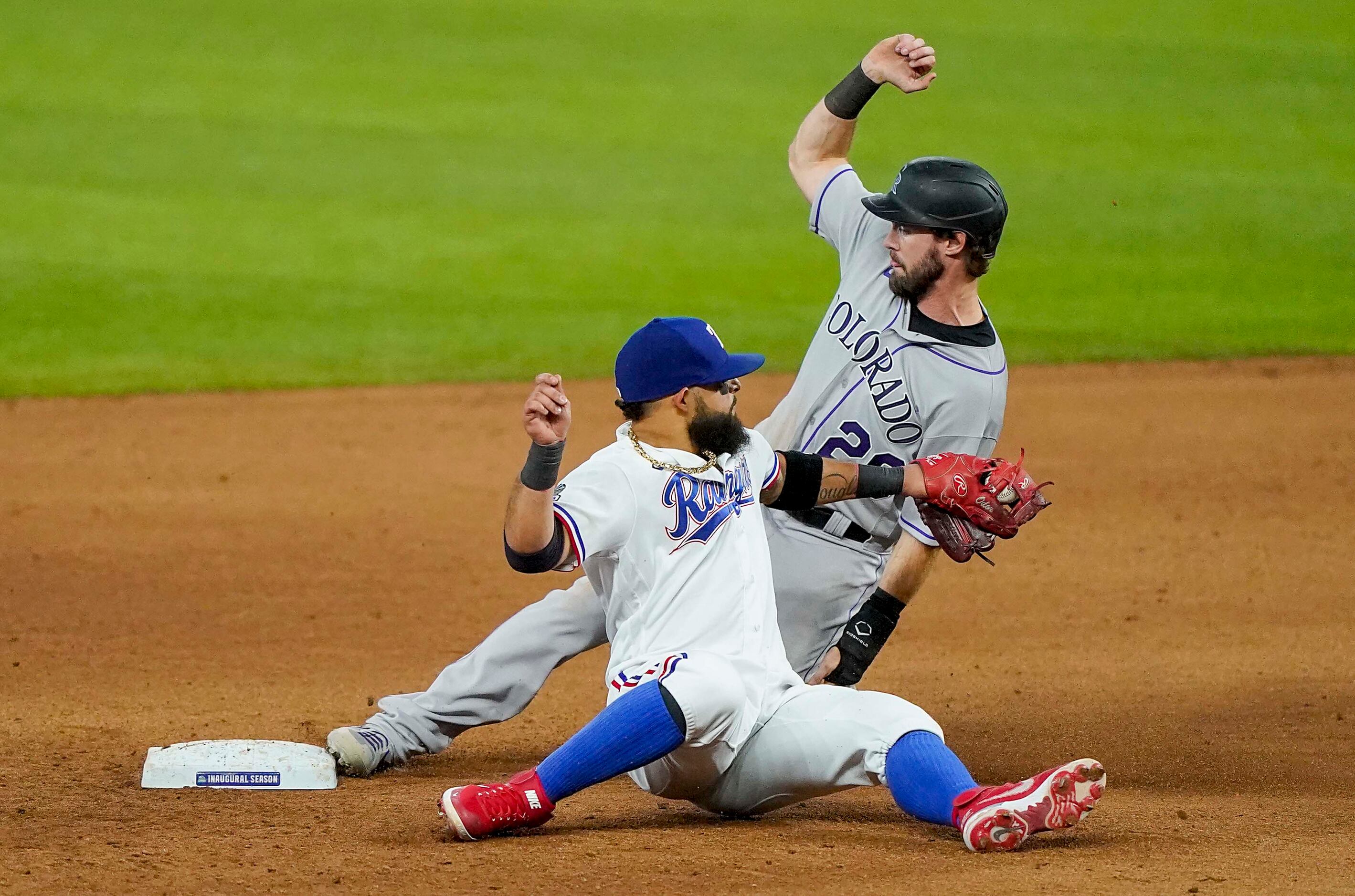 Colorado Rockies center fielder David Dahl slides past the tag from Texas Rangers second...