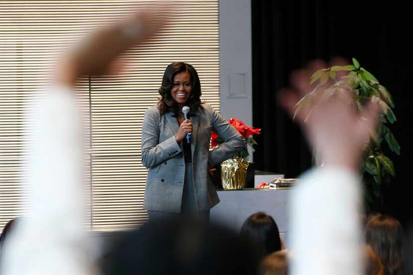 Dallas high school students wave to former first lady Michelle Obama as she takes the stage...