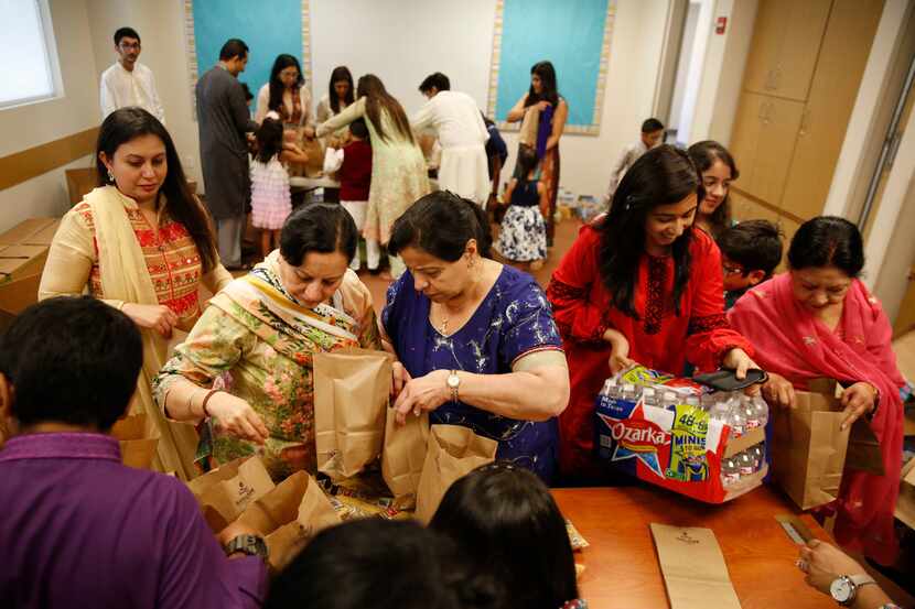 Volunteers pack snack bags to be donated to various area food pantries at Ismaili Jamatkhana...