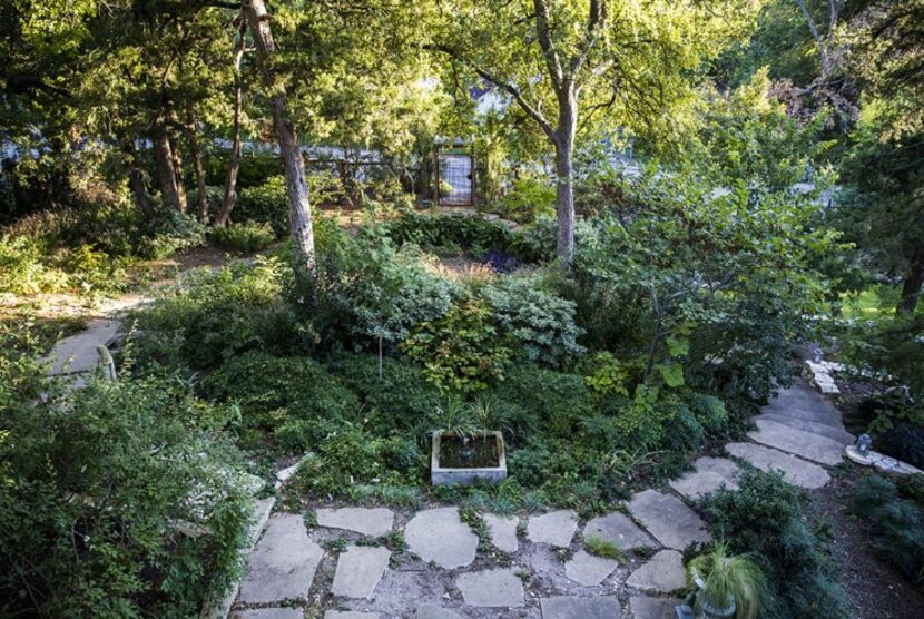 
The view from the front porch shows the lot’s sharp slope to the street and the garden...