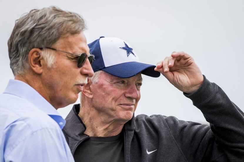 Dallas Cowboys owner Jerry Jones adjusts his cap as he chats with St. Louis Rams owner Stan...