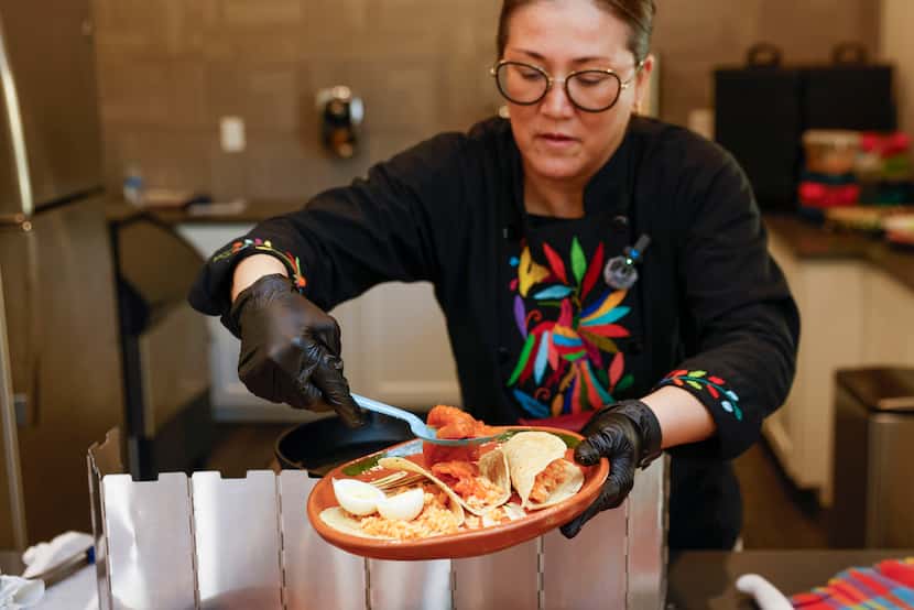 Martina de la Guti, owner of Santa Maria Artisan Kitchen catering, prepares a plate of tacos...