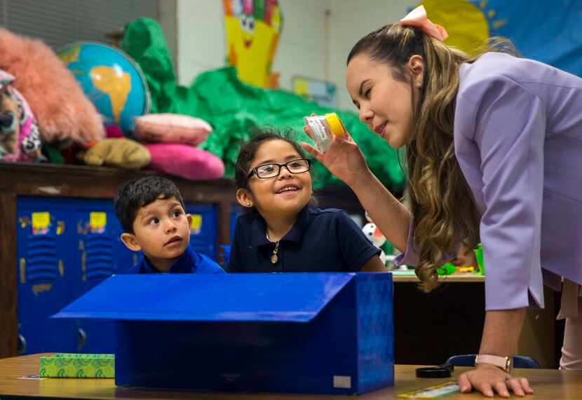 La maestra de prekínder, Rosa Yabur (der.) examina una muestra de fluorita con sus...