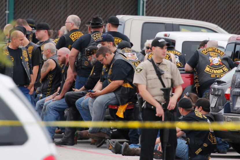  A McLennan County deputy stands guard near a group of bikers in the parking lot of Waco's...