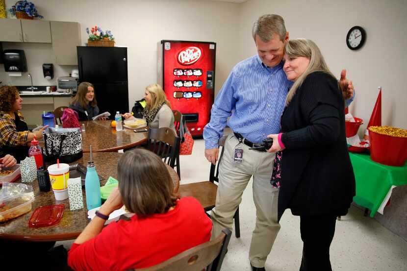 Incoming Allen ISD superintendent Scott Niven receives a goodbye hug from instructional...