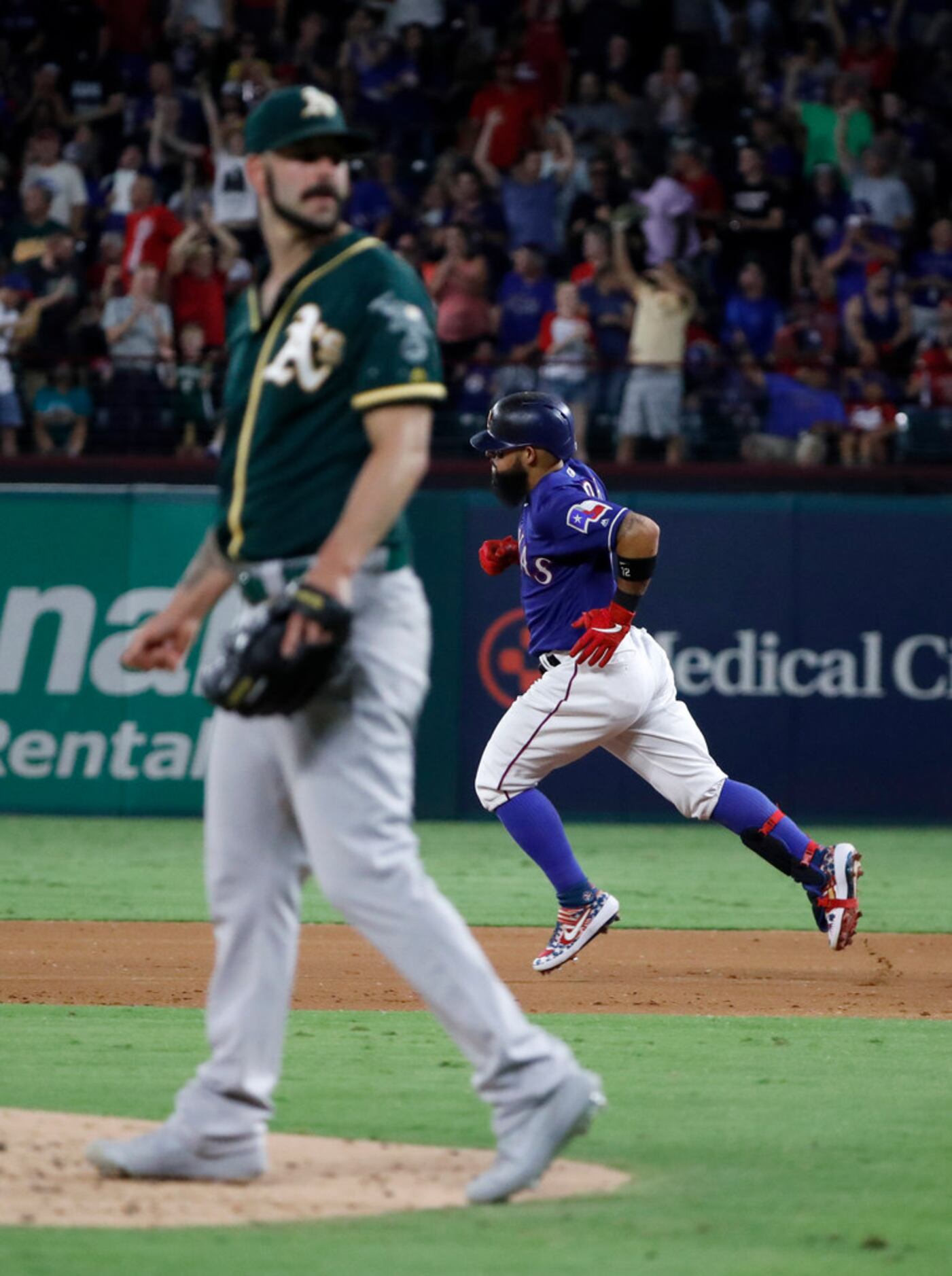 Oakland Athletics' Mike Fiers, left, stands on the front of the mound as Texas Rangers'...