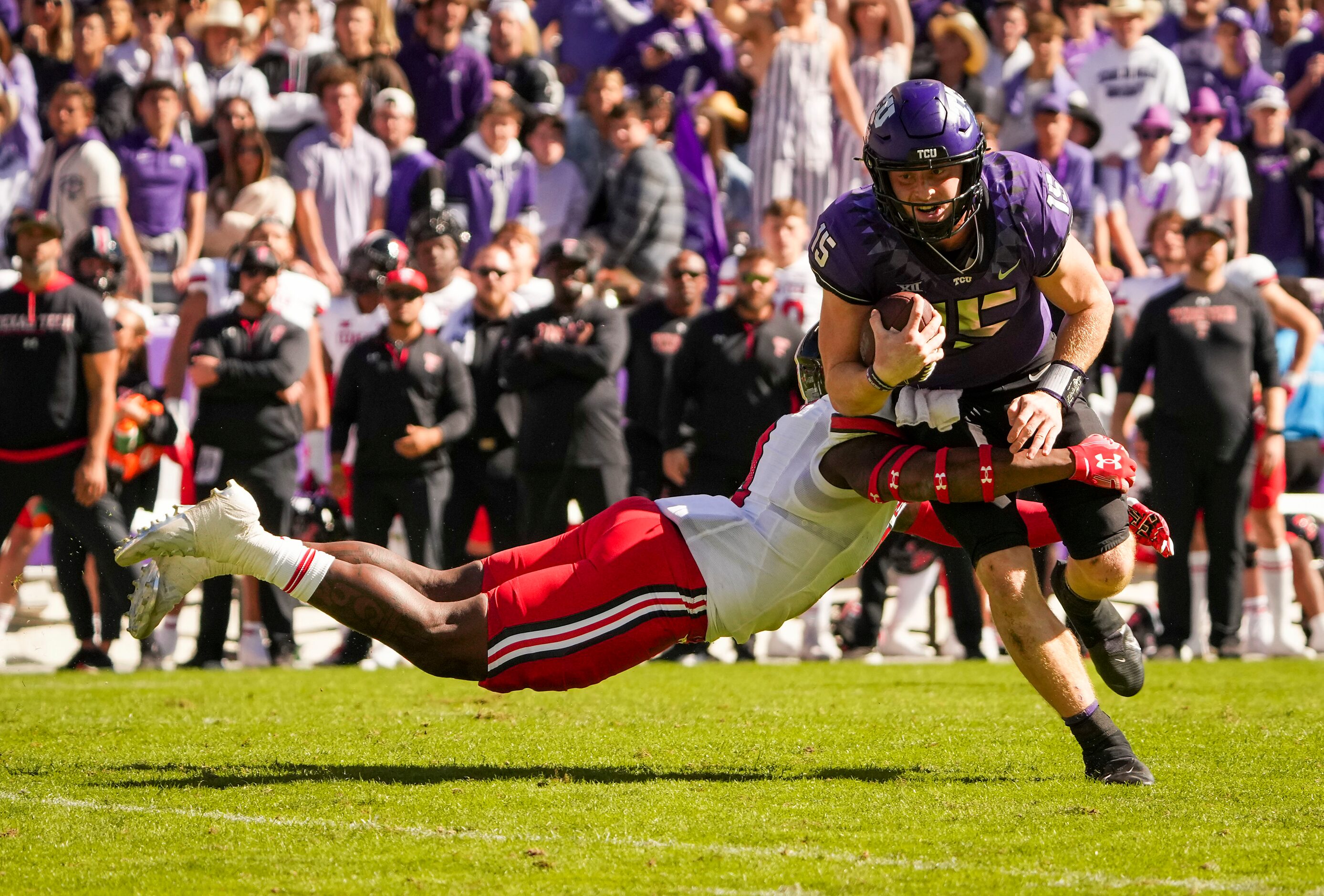 TCU quarterback Max Duggan (15) is brought down by Texas Tech defensive back Marquis Waters...