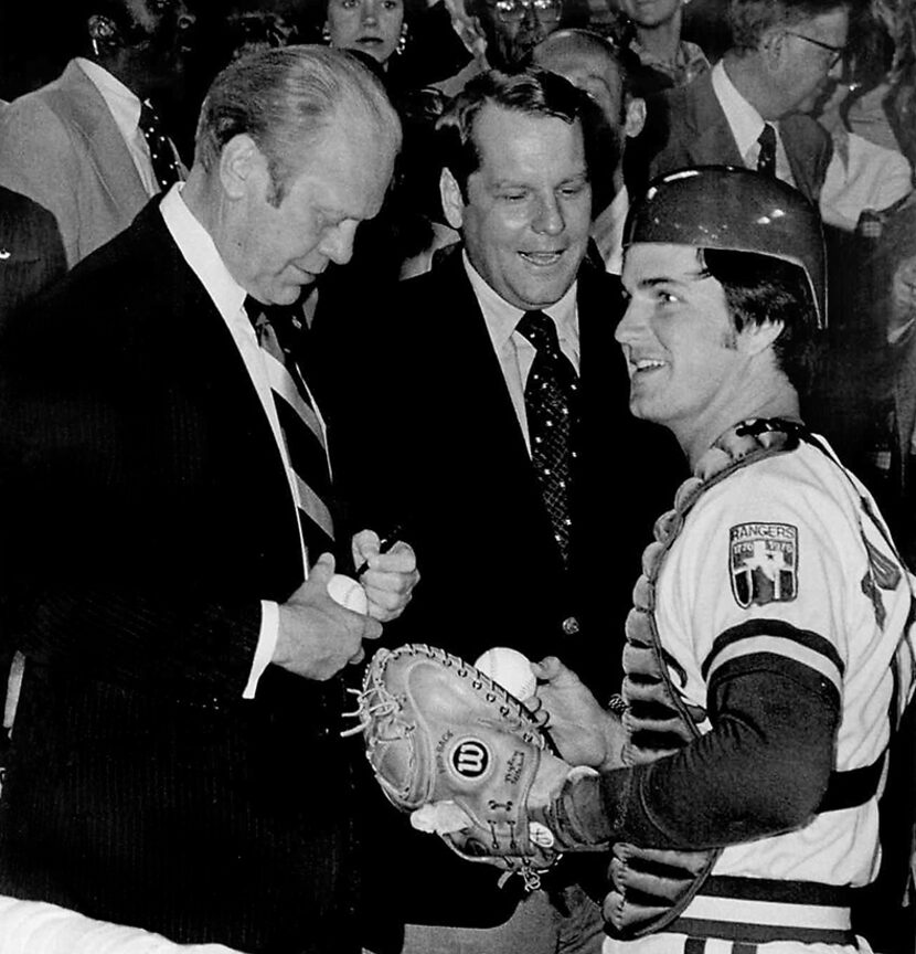  President Gerald Ford autographs a baseball for Texas Rangers catcher Jim Sundberg, as...