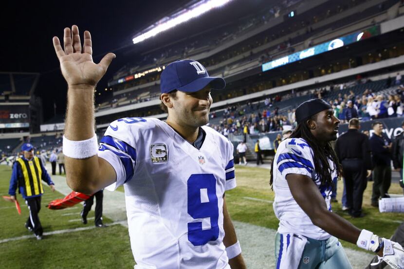Dallas Cowboys quarterback Tony Romo (9) waves to cheering fans as he leaves the field with...