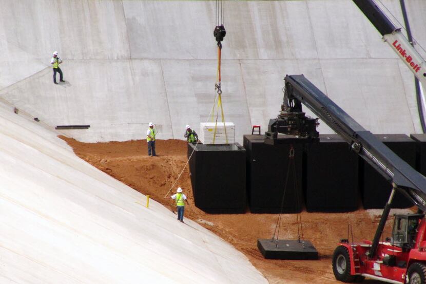 Crews from Waste Control Specialists in 2013 load the first of two containers with low-level...