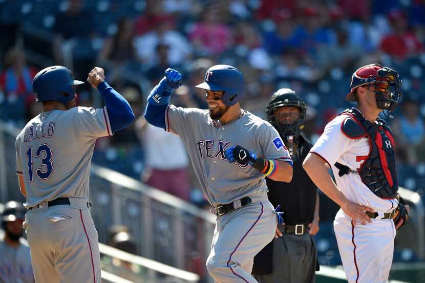 Texas Rangers' Robinson Chirinos, center, celebrates his three-run home run with Joey Gallo...