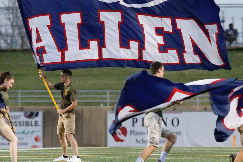 Aidan McGlothlin, 16, with the Allen High School Marine Core JROTC waves an Allen flag after...