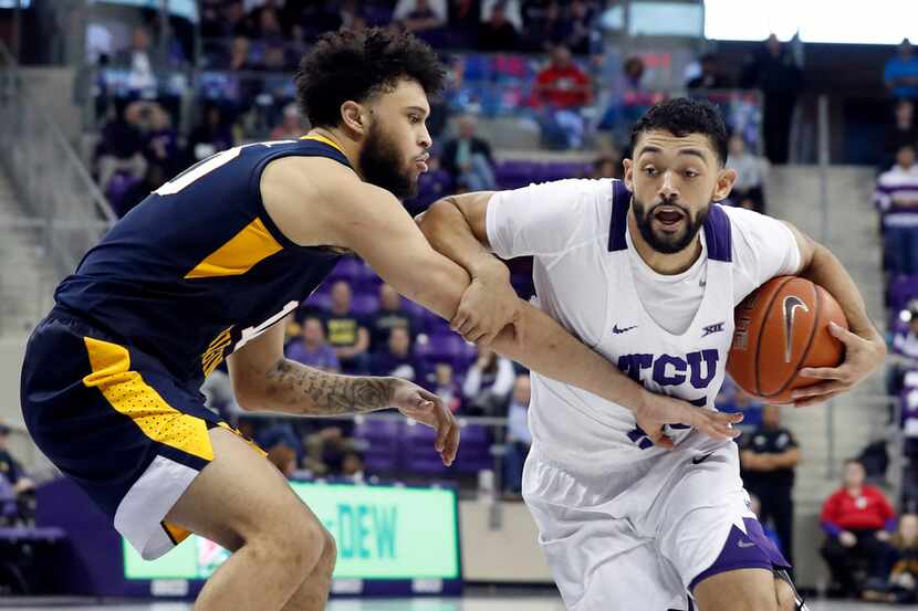 West Virginia guard Jermaine Haley (10) defends against a drive to the basket by TCU guard...