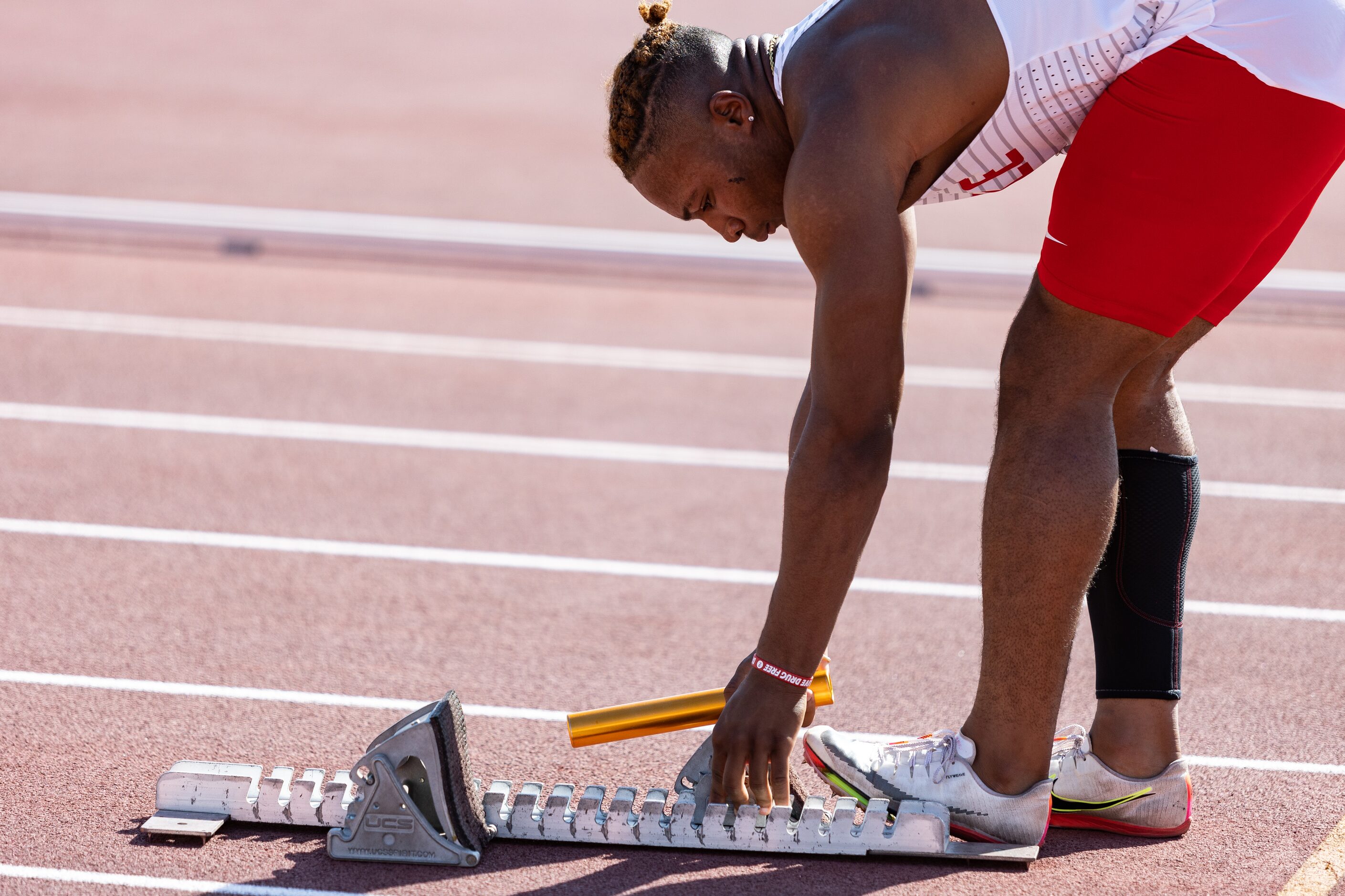 Caden Durham of Duncanville adjusts the starting blocks ahead of the boys' 4x100-meter relay...