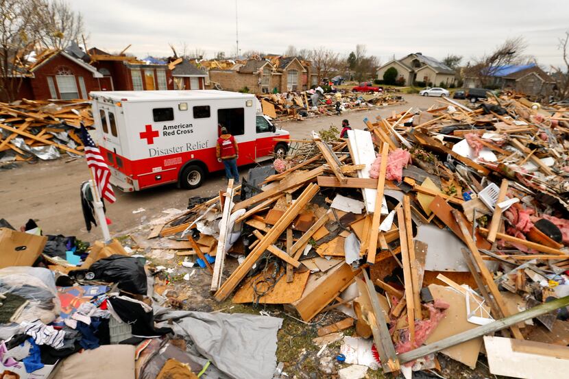 An American Red Cross Disaster Relief truck stops between the mounds of debris lining...